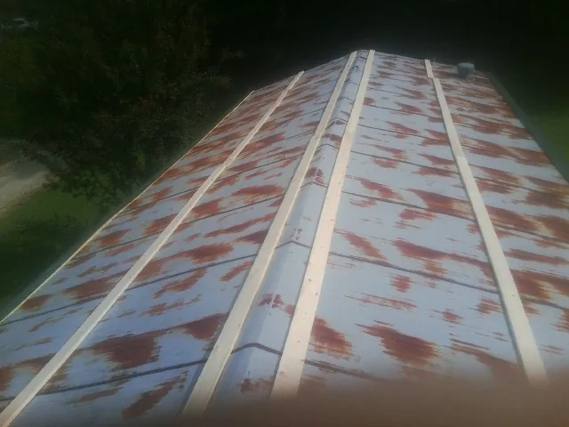 Rusted metal roof panels with new wood purlins before replacement — Storm Damage Roof Repair in West Point by Roofing Brothers